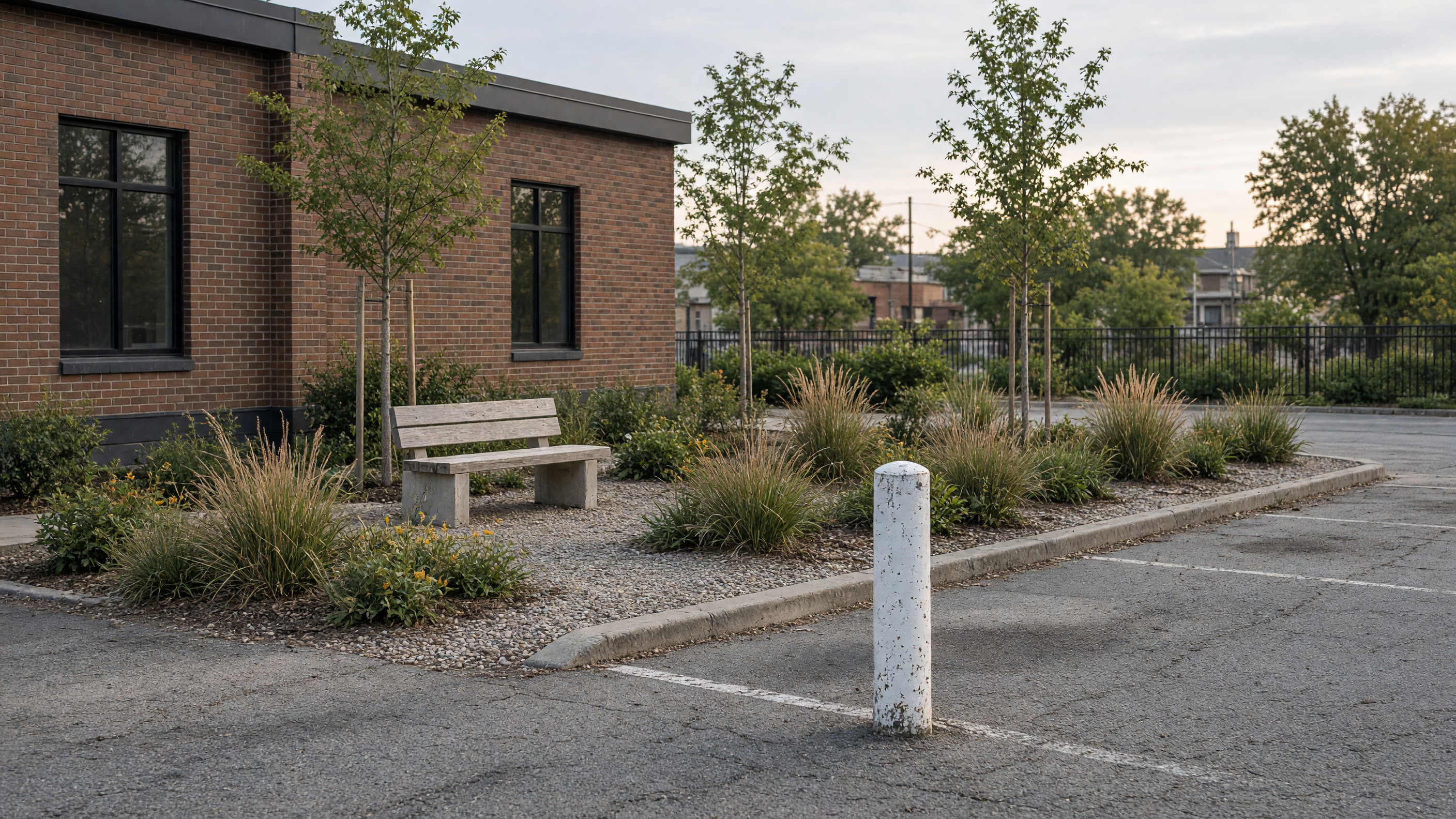 A single bollard painted white at the edge of what used to be a painted stall